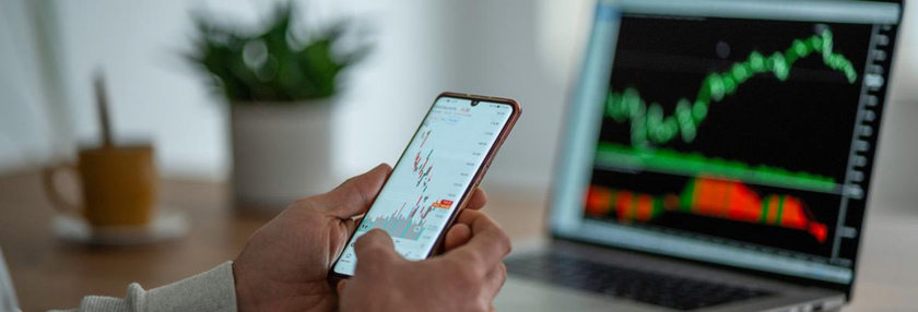 Person using smartphone in front of a screen