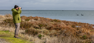 Man with binoculus looking at the sea
