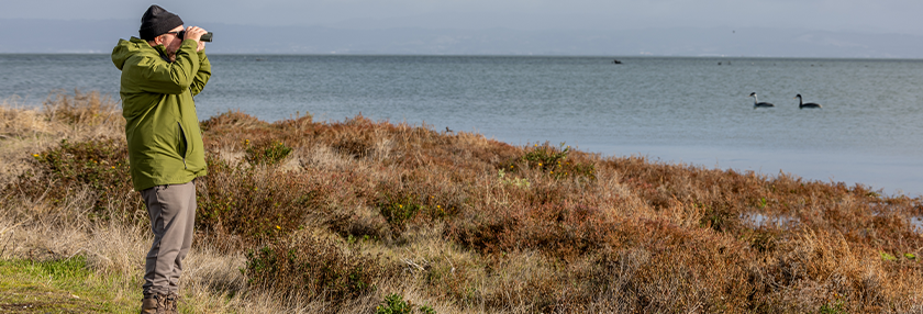 Man with binoculus looking at the sea